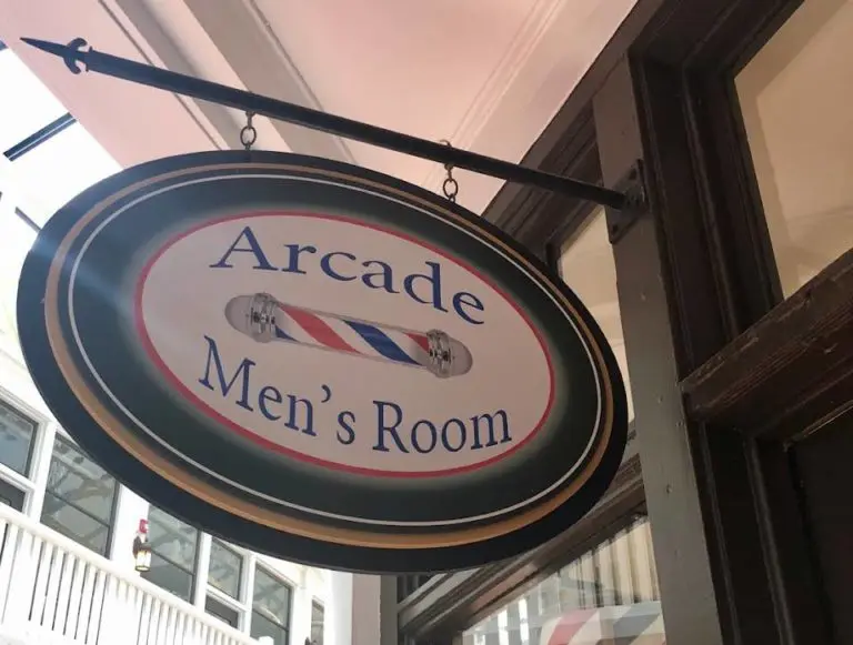 An image of the hanging sign for The Men’s Room Barbershop.
