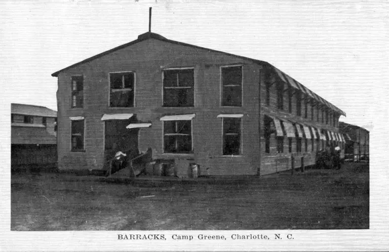 A postcard showing the exterior of the wooden barracks at Camp.