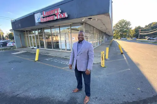 An image of Christopher Dennis in front of Chase Bank before it was renovated.