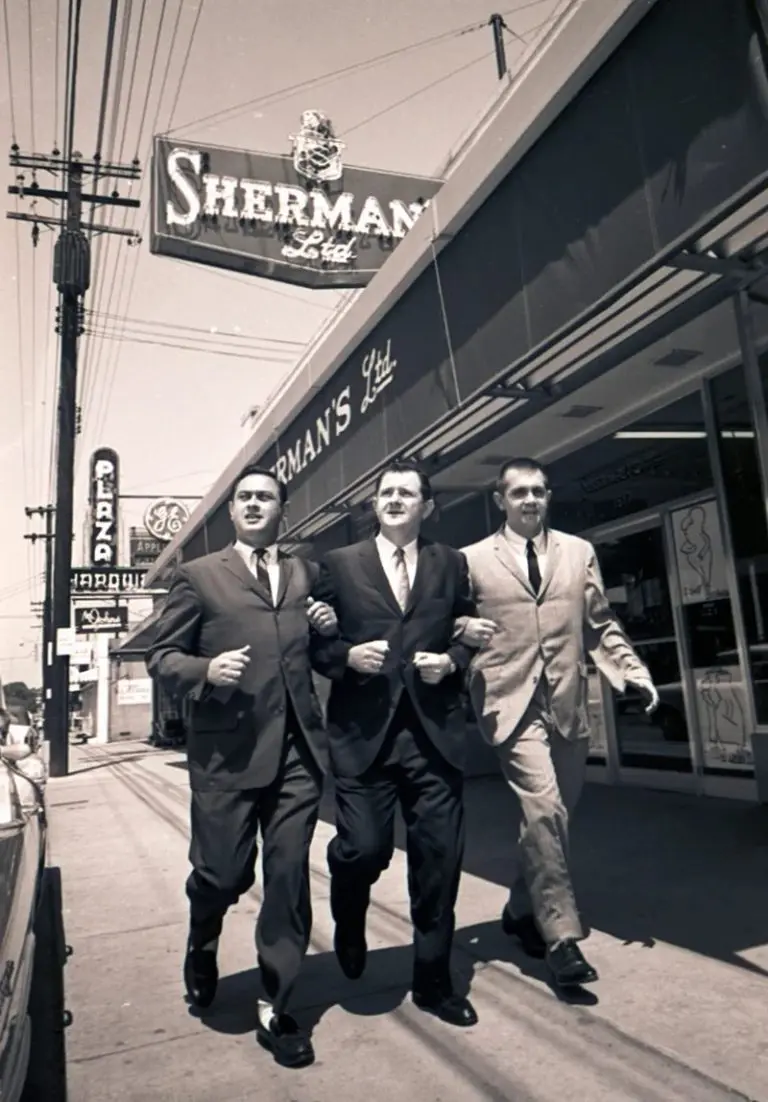 A picture of Sherman, Alvin, and Leon Levine strolling down the sidewalk together in 1960.