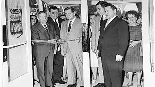 A picture of Leon Levine cutting the ribbon to a new store in 1964.