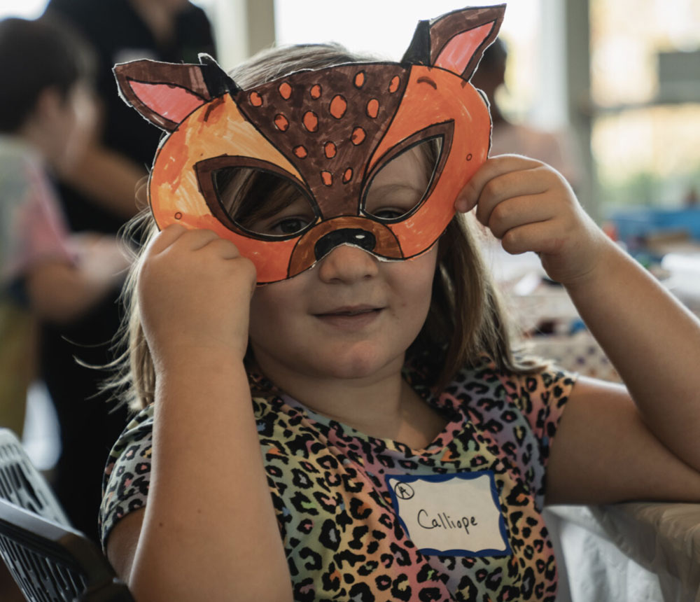 kids summer camps & day camps - little girl wearing a paper mask