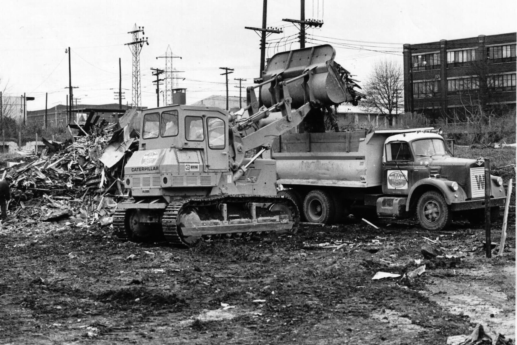 A dump truck being loaded with debris.